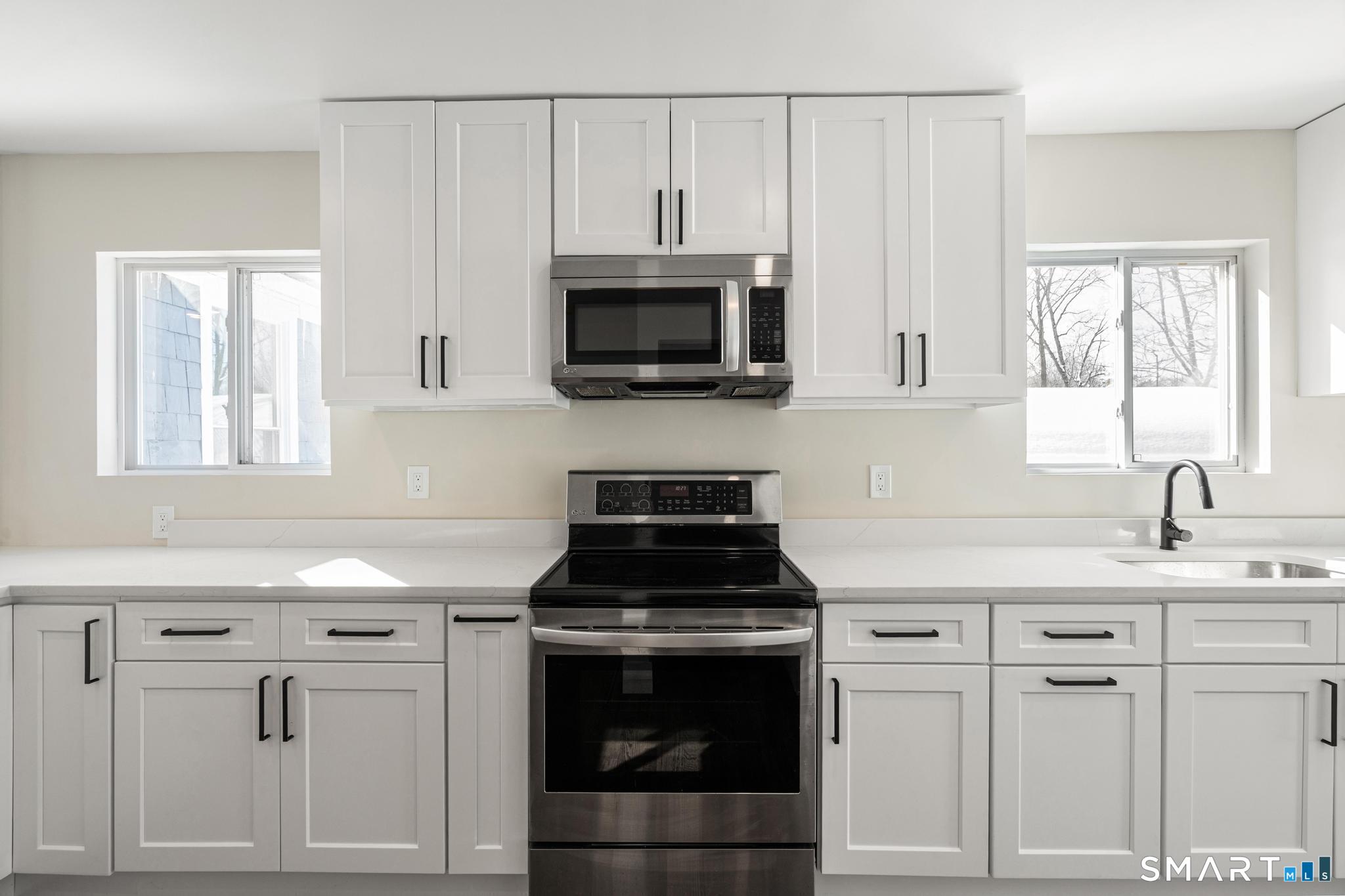 6 Juniper Ridge Drive Danbury, CT 06811 - Photo 15 of 36 a kitchen with white cabinets and black stove top oven with granite countertops
