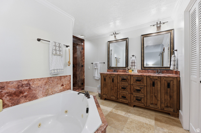 2342 Charros Road Sandy, UT 84092 - Photo 38 of 94 Bathroom featuring a corner jetted tub with red-hued stone surround, a dual vanity with wood-finish cabinetry, two framed mirrors, and stone tile flooring