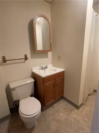 a bathroom with a toilet sink and mirror