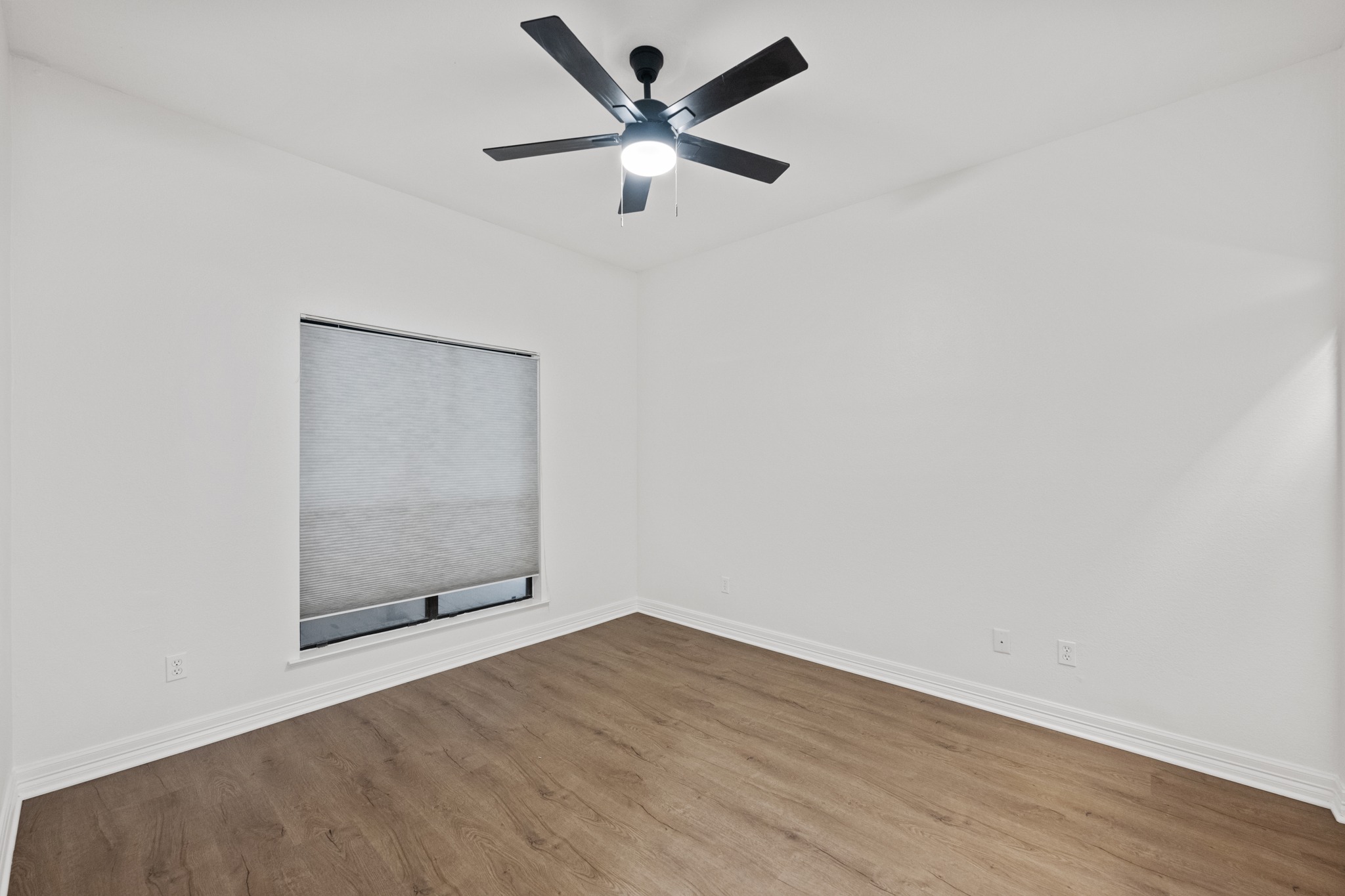 409 East 38th Street, Unit 101 Austin, TX 78705 - Photo 17 of 27 Second bedroom with new floors, paint and ceiling fan.