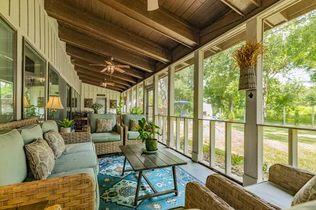 a living room with furniture and a floor to ceiling window