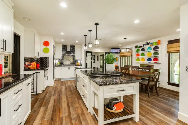 a kitchen with stainless steel appliances kitchen island granite countertop a stove a sink and a microwave