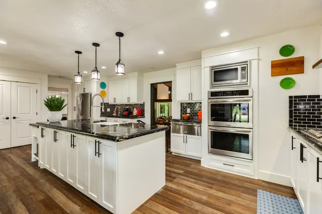 a kitchen with granite countertop a stove and cabinets