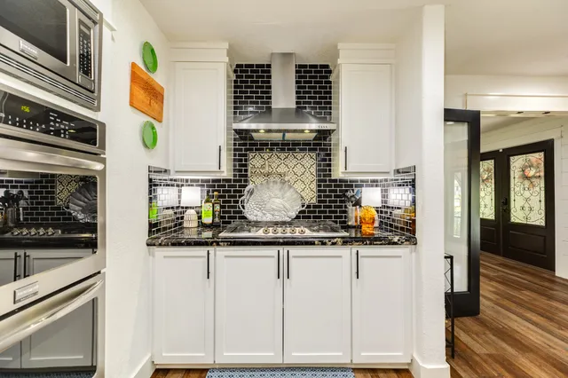 a dining room with wooden floor a chandelier a wooden table and chairs