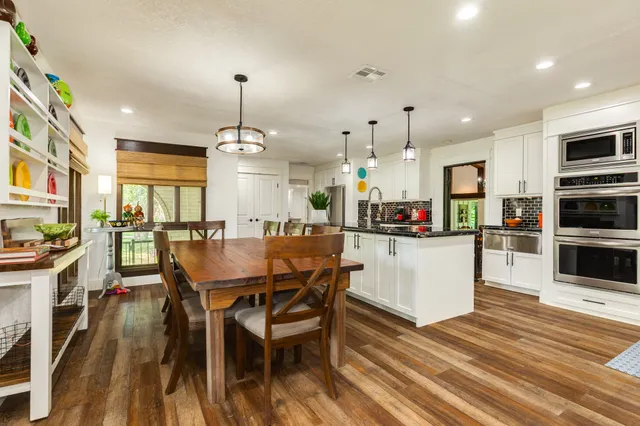 a kitchen with stainless steel appliances granite countertop a refrigerator and wooden floor