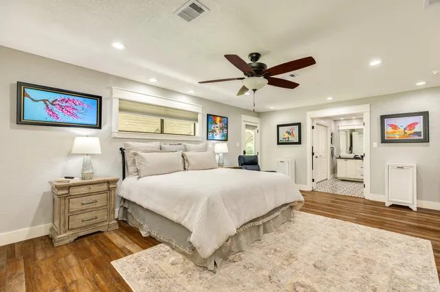 a spacious bathroom with a double vanity sink a mirror a bathtub and a window
