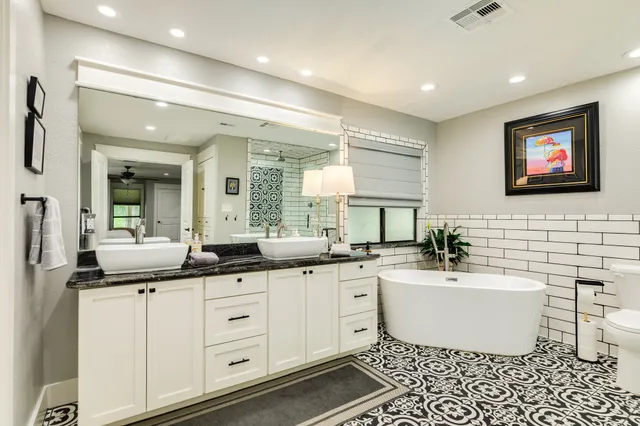 a spacious bathroom with a granite countertop sink and a mirror