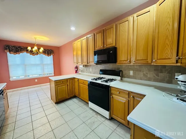 a kitchen with stainless steel appliances a stove a sink a microwave and cabinets