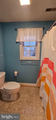 a bathroom with a toilet and a shower curtain