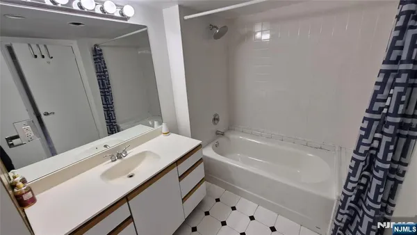 a bathroom with a sink a toilet a mirror and shower