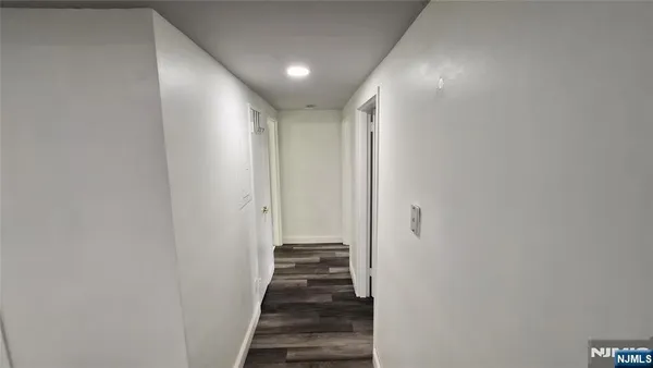 a view of a hallway with wooden floor and entryway