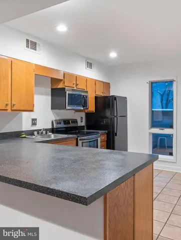 a kitchen with stainless steel appliances a sink a stove and a refrigerator