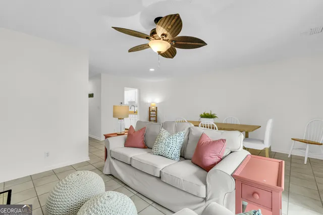 a living room with furniture and a ceiling fan