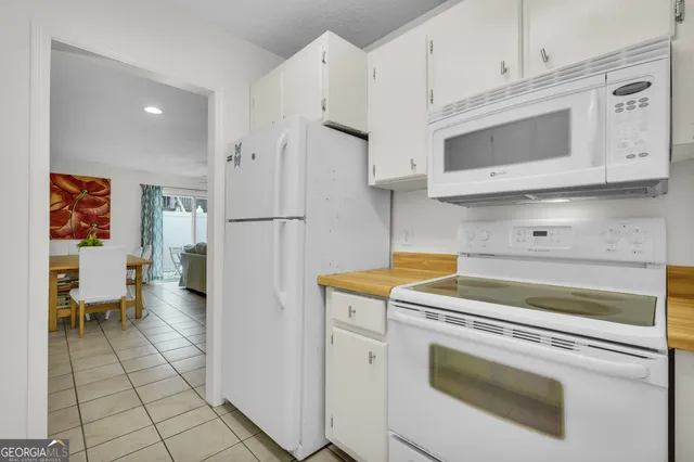 a kitchen with stainless steel appliances white cabinets and a refrigerator