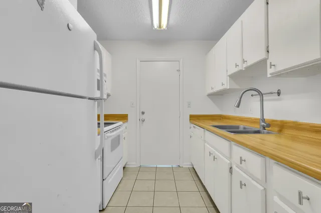 a kitchen with a sink a refrigerator and cabinets