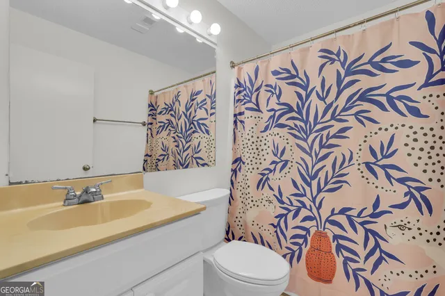 a bathroom with a sink and mirror with toilet