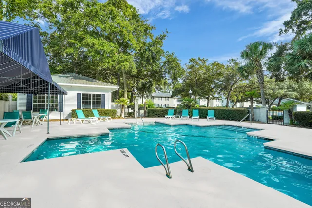 a view of backyard with swimming pool and outdoor seating