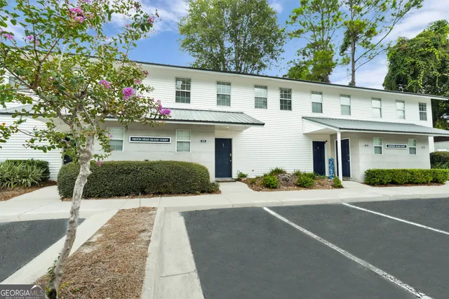 a front view of a house with a yard and potted plants