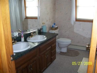 8806 Liable Road Highland, IN 46322 - Photo 6 of 10 a bathroom with a granite countertop toilet a sink and a mirror