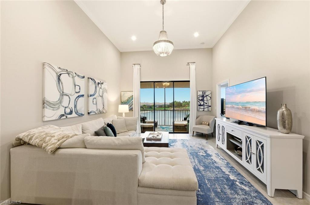 9365 Pocida Court, Unit 202 Naples, FL 34119 - Photo 11 of 40 a living room with furniture and a flat screen tv
