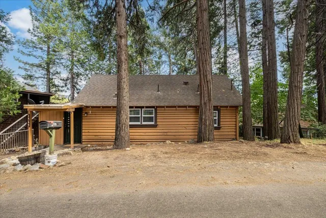 front view of a house with large trees