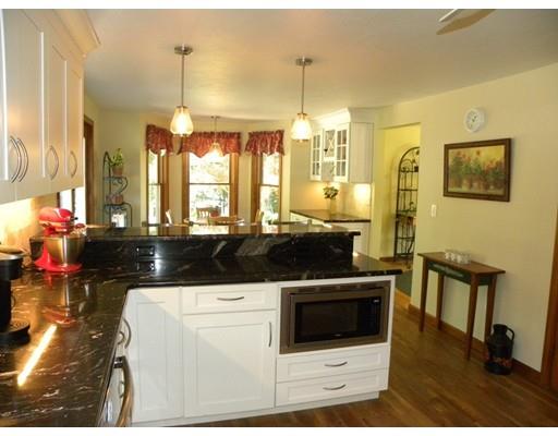 30 Wamsutta Ridge Road Charlton, MA 01507 - Photo 13 of 42 a kitchen with a stove a refrigerator a sink a dining table and chairs with wooden floor