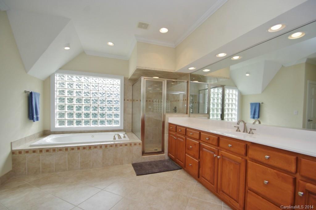 1640 Windy Ridge Road Charlotte, NC 28270 - Photo 15 of 22 a spacious bathroom with a double vanity sink large mirror and a bathtub