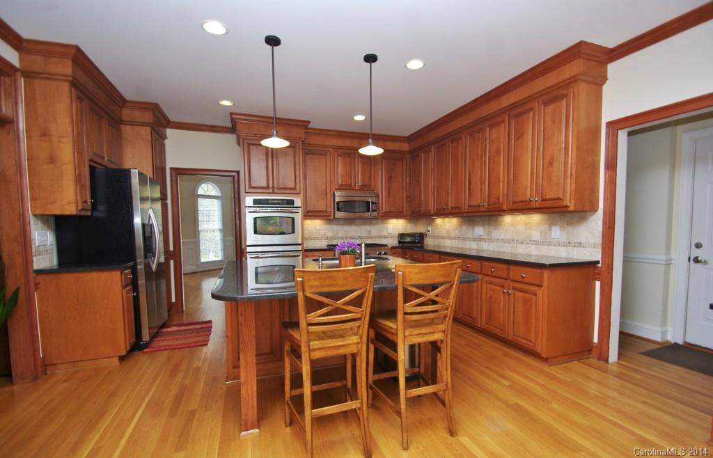 1640 Windy Ridge Road Charlotte, NC 28270 - Photo 10 of 22 a kitchen with stainless steel appliances granite countertop a refrigerator a stove top oven a sink dishwasher and a dining table with wooden floor