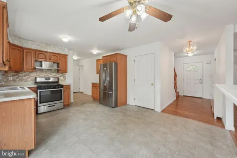 a view of kitchen with stainless steel appliances kitchen island empty cabinets and wooden floor