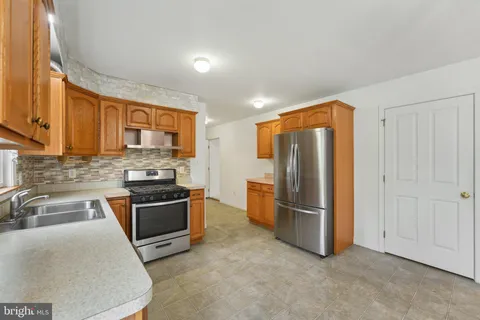 a kitchen with stainless steel appliances granite countertop a refrigerator stove and sink