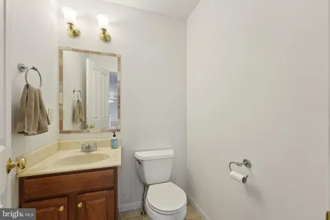 a bathroom with a sink vanity mirror and toilet