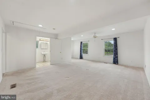 a view of an empty room with closet and a window