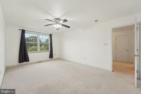 a view of a big room with windows and chandelier fan