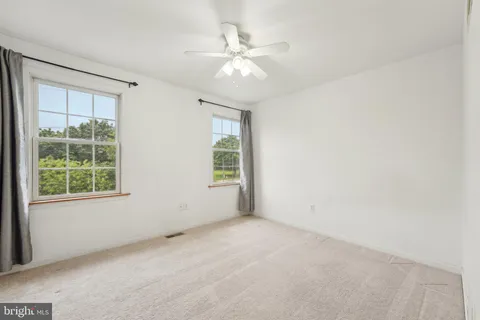 an empty room with a window and a fan
