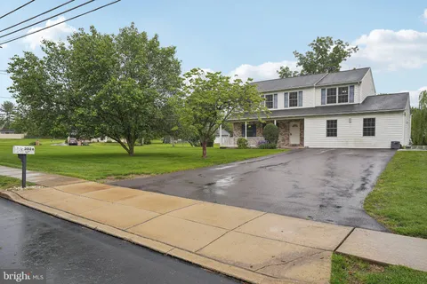 a view of a house with a yard and potted plants