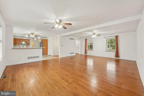 a view of an empty room with window and wooden floor