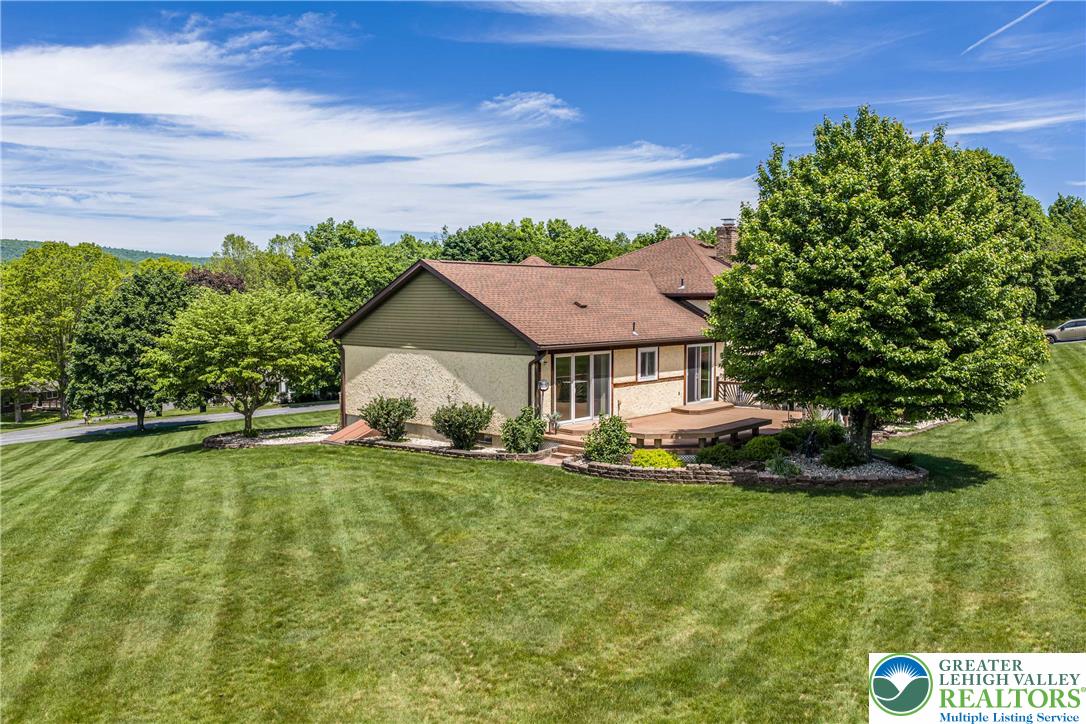 947 Tamenend Road Bath, PA 18014 - Photo 44 of 61 A sprawling lawn offers generous outdoor space alongside a multi-level wooden deck perfect for entertaining.