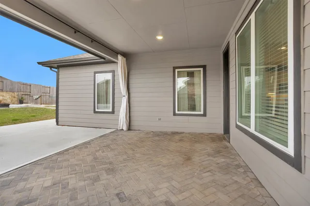 a front view of a house with a garden and patio