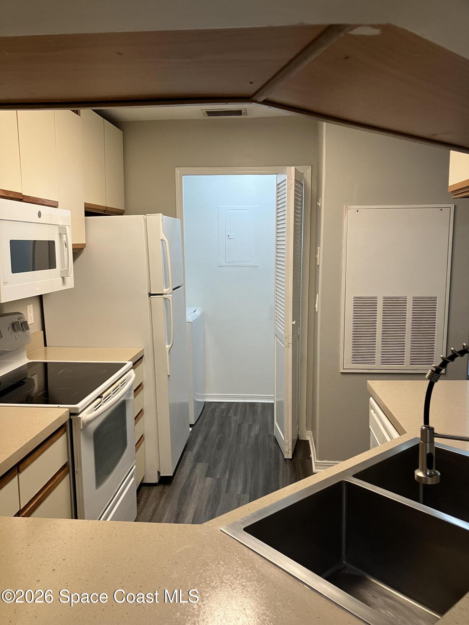 7667 North Wickham Road, Unit 1318 Melbourne, FL 32940 - Photo 5 of 18 a kitchen with stainless steel appliances granite countertop a sink stove and refrigerator