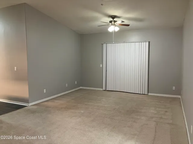an empty room with fan and windows