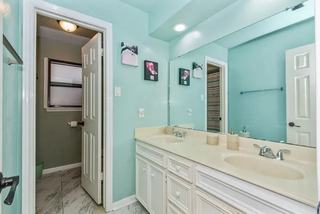 a bathroom with a double vanity sink mirror and shower