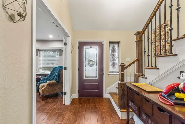 a view of a hallway with wooden floor and staircase