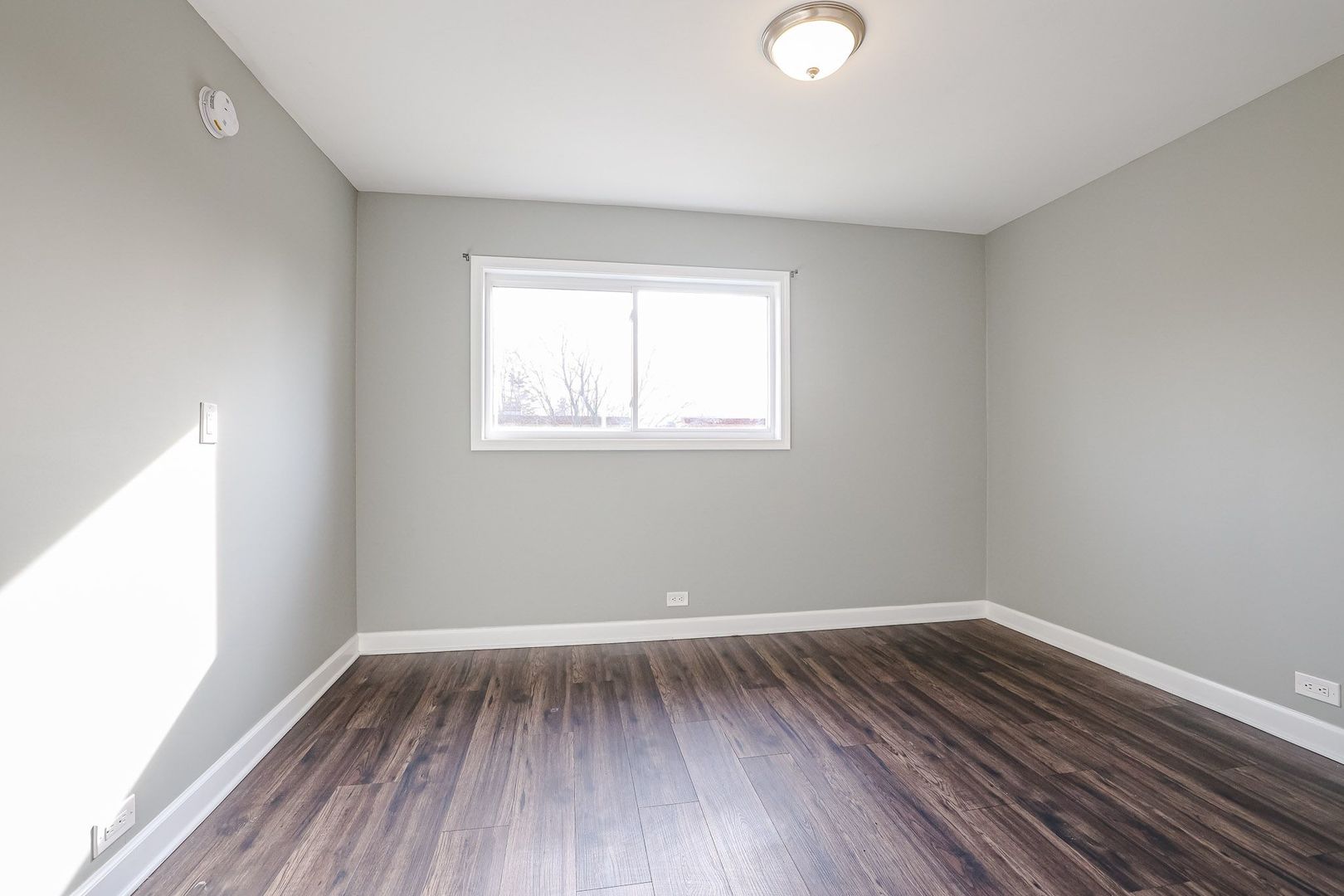 746 Walnut Street, Unit 2E Waukegan, IL 60085 - Photo 12 of 21 an empty room with wooden floor and windows