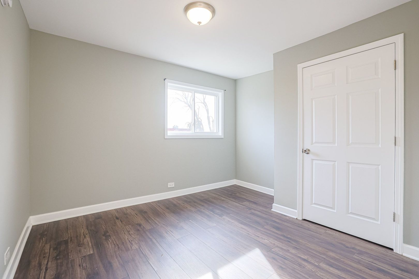 746 Walnut Street, Unit 2E Waukegan, IL 60085 - Photo 17 of 21 an empty room with wooden floor and windows