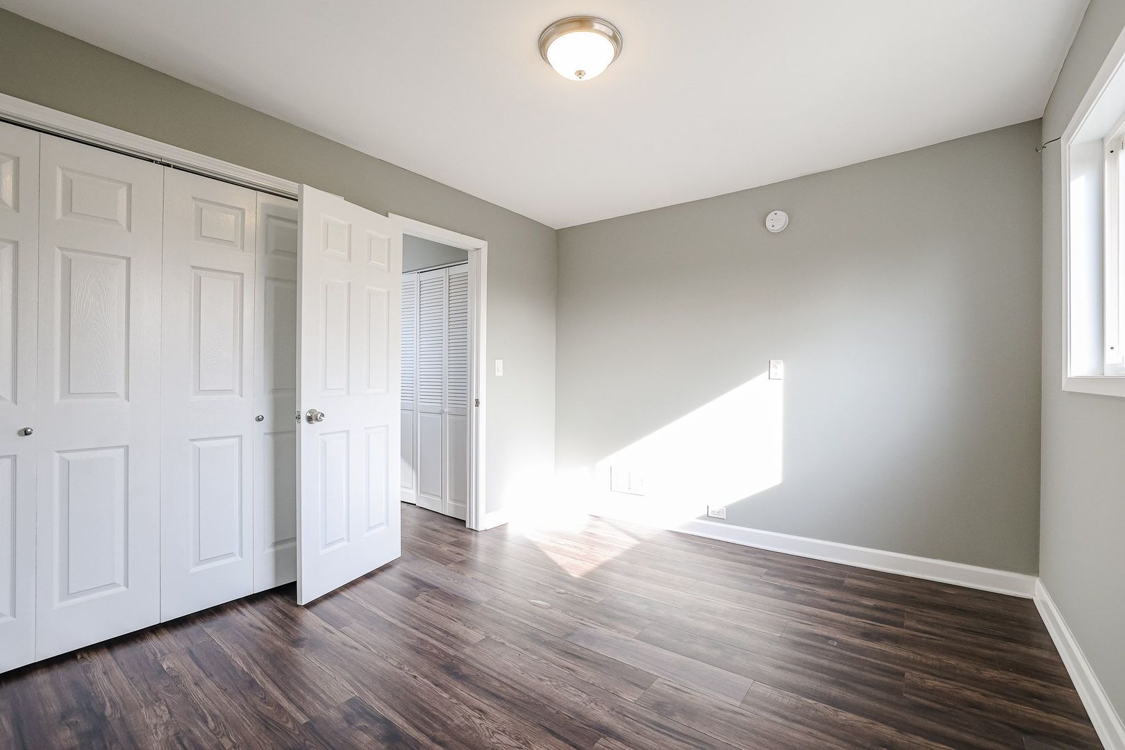 746 Walnut Street, Unit 2E Waukegan, IL 60085 - Photo 18 of 21 a view of an empty room with wooden floor and a window