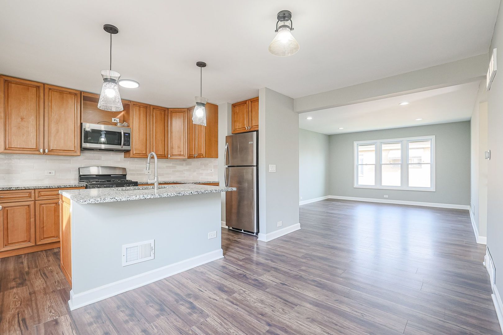 746 Walnut Street, Unit 2E Waukegan, IL 60085 - Photo 7 of 21 a kitchen with stainless steel appliances granite countertop a refrigerator a sink dishwasher a stove and white cabinets with wooden floor