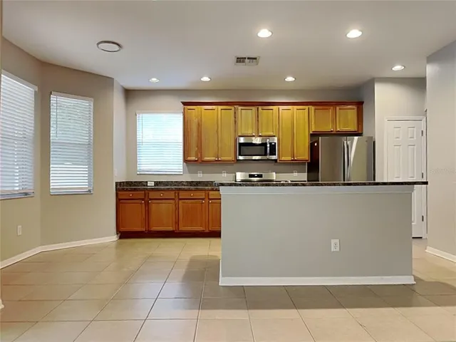 a kitchen with stainless steel appliances a refrigerator sink and microwave