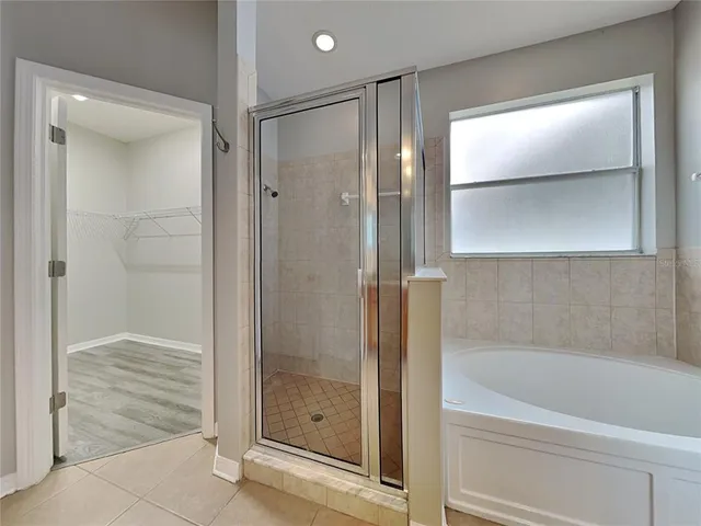 a bathroom with a glass shower door and a window