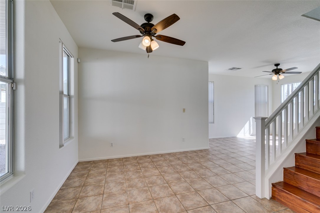 4957 Miners Ridge Drive Las Vegas, NV 89122 - Photo 16 of 39 This bright and airy living area features ceramic tile flooring and prominent wooden stairs.