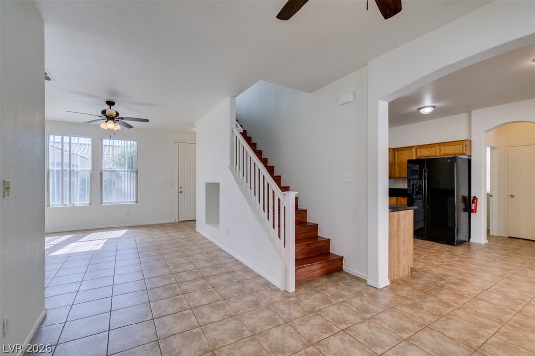 4957 Miners Ridge Drive Las Vegas, NV 89122 - Photo 18 of 39 Bright, open living space with tiled floors, a staircase, and a view of the kitchen area.